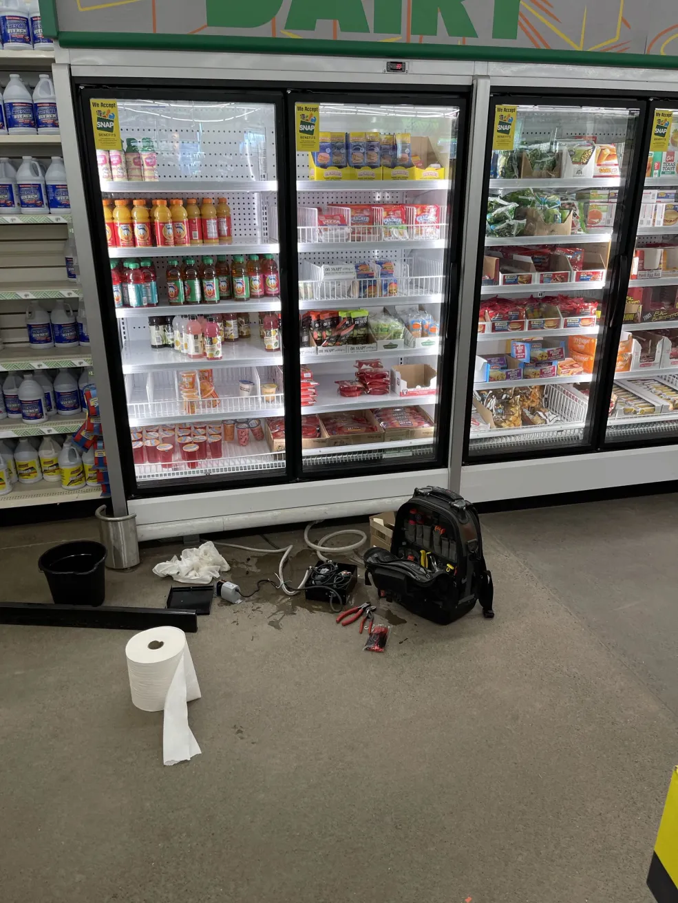 Central Minnesota Appliance Repair technician diagnosing a glass-door commercial dairy cooler at a Saint Paul, MN grocery store