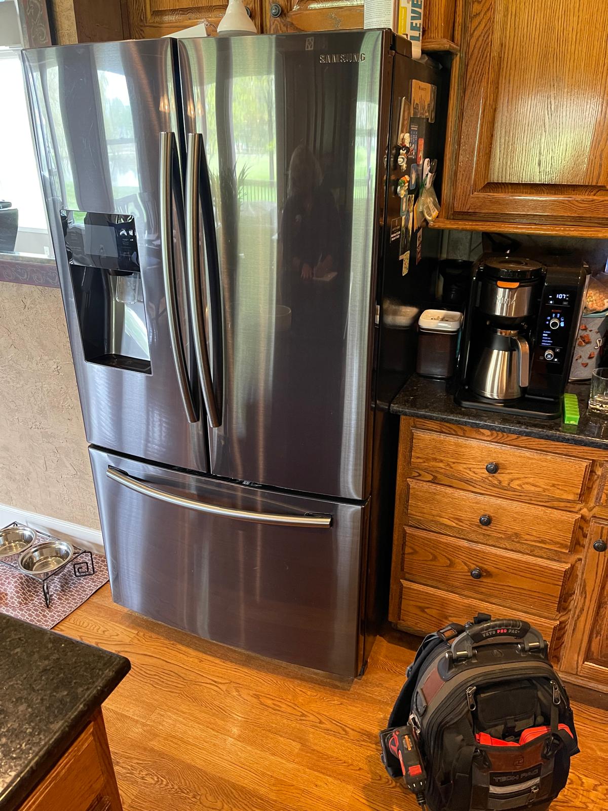 Freezer repair technician servicing an upright freezer in Minneapolis MN