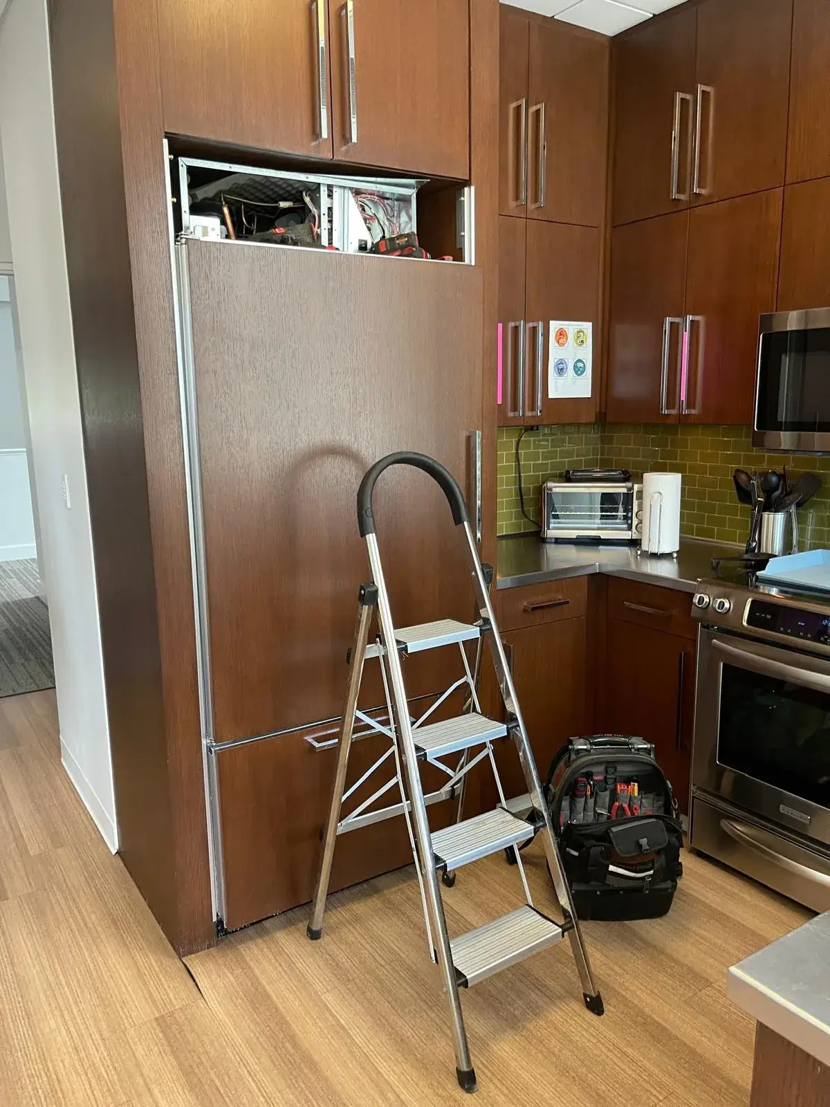 Central Minnesota Appliance Repair technician servicing a built-in refrigerator in a Minneapolis home